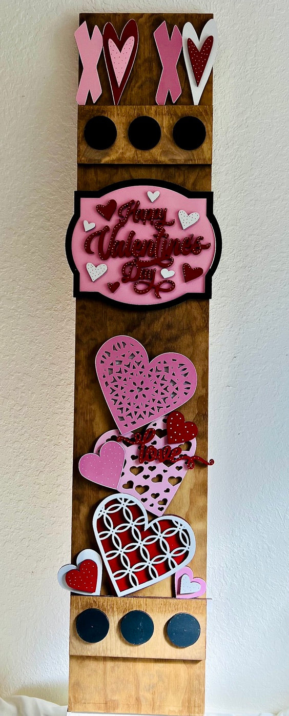 Decorative wooden panel with Valentine's Day-themed cutouts on a white background